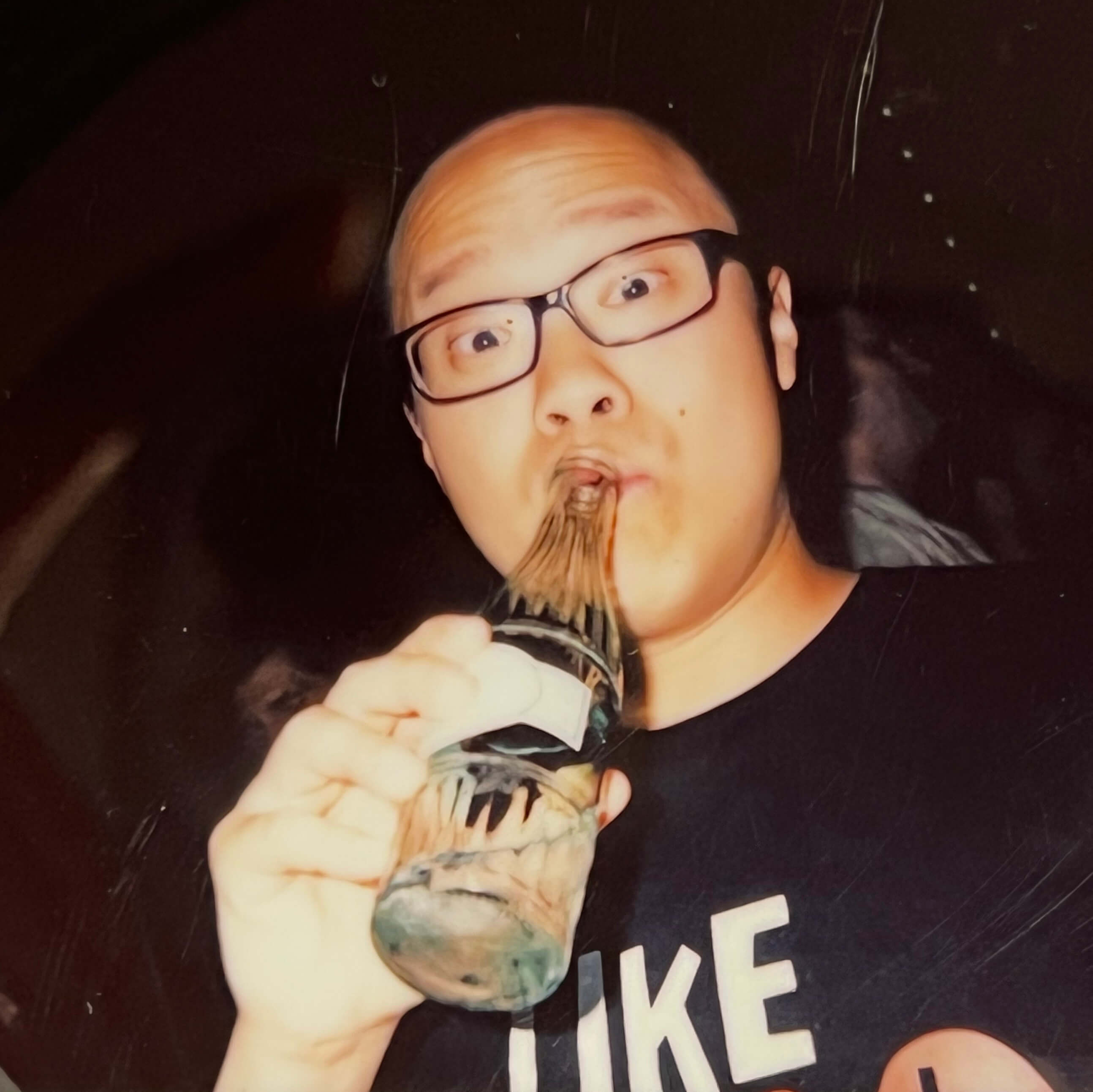 A Keen employee drinking from a glass bottle